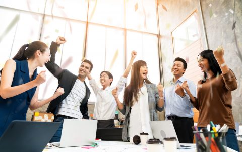 Multi-ethnic businesspeople cheering with business project successful in meeting room office backgroound