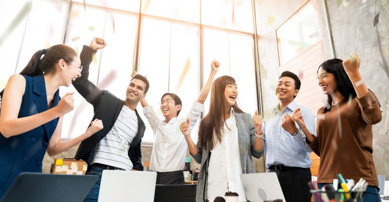 Multi-ethnic businesspeople cheering with business project successful in meeting room office backgroound